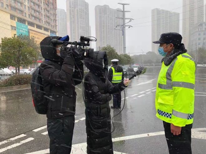 孝感市融媒體中心楊亞玲（風(fēng)雪中，采訪疫情期間重返一線的退休警察）_副本.jpg.jpg